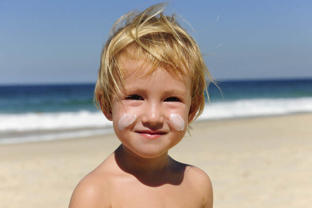 Jongetje met zonnebrand creme op zijn gezichtr